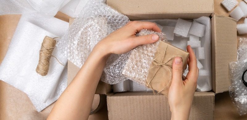 فردی در حال بسته بندی با پلاستیک حباب‌دار-parcel-packing